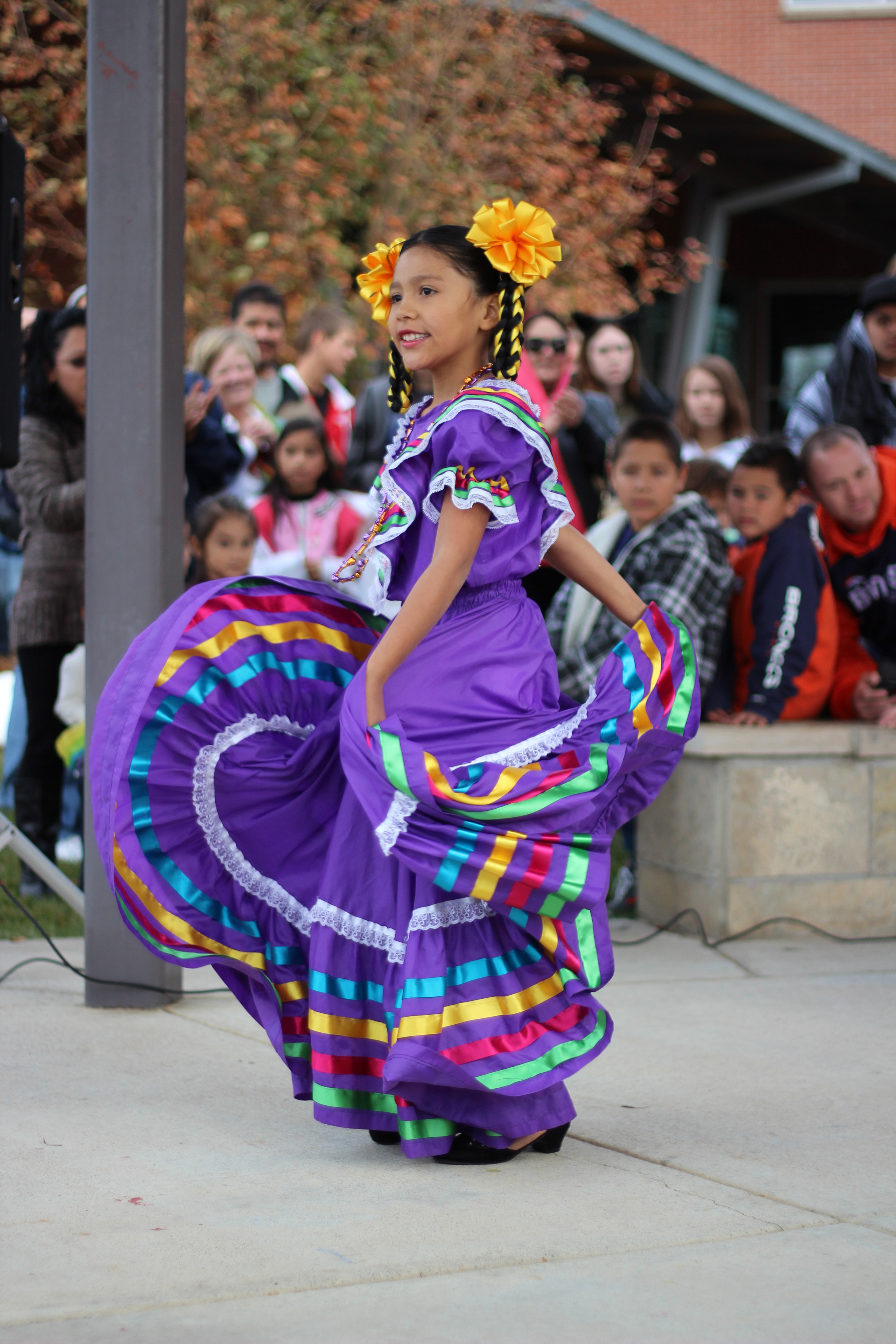Girl in traditional Mexican purple dress at Day of the Dead event in Longmont, CO