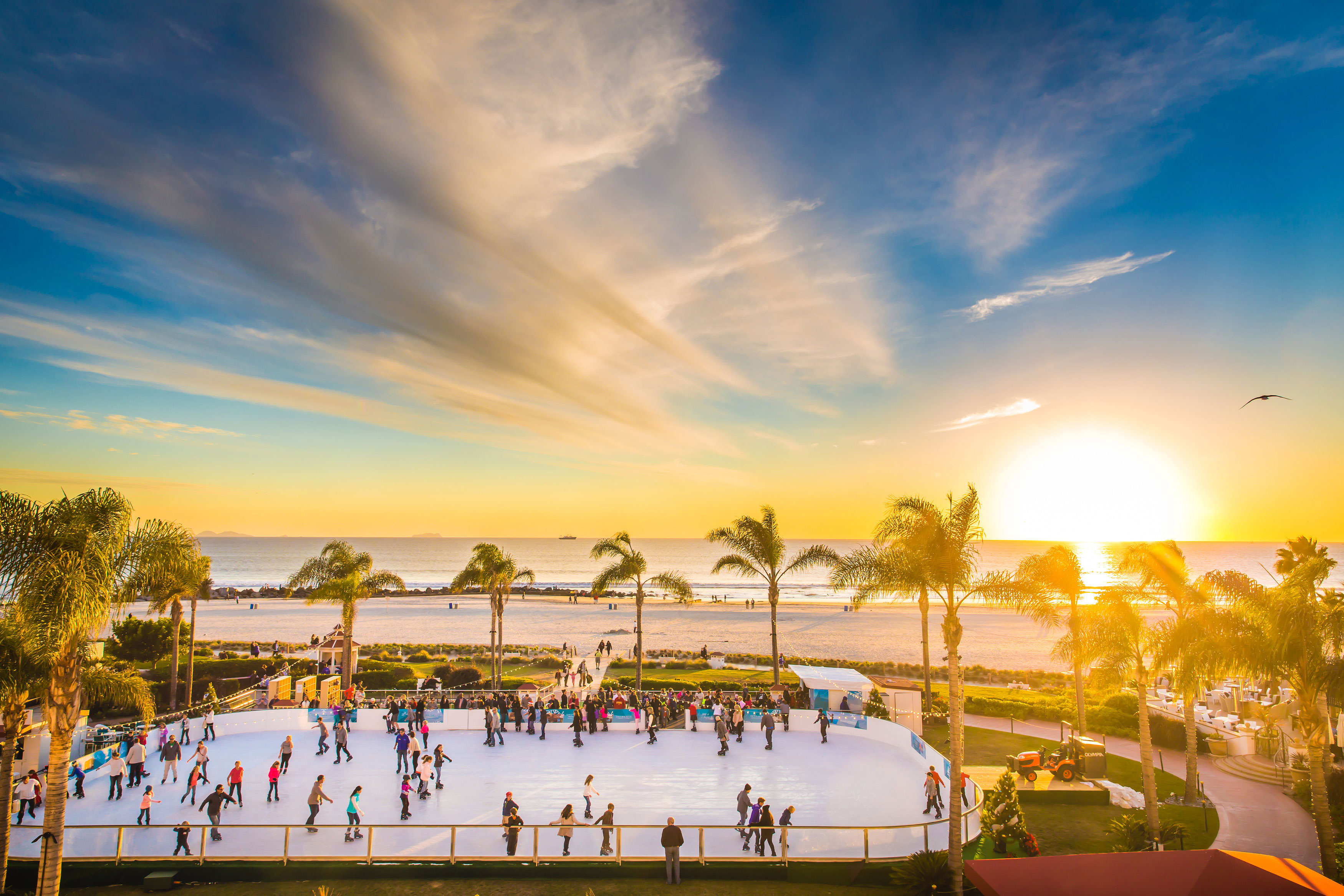 Families ice skating on the beach at the Hotel del Coronado in California at dusk