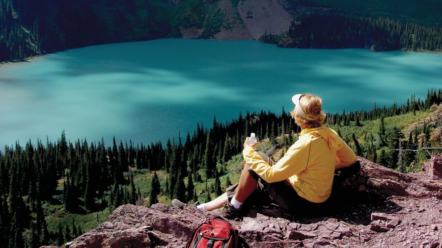 Person looking at the turquoise lakes and mountains on one of the best hikes in the West, Grinnell Glacier Trail