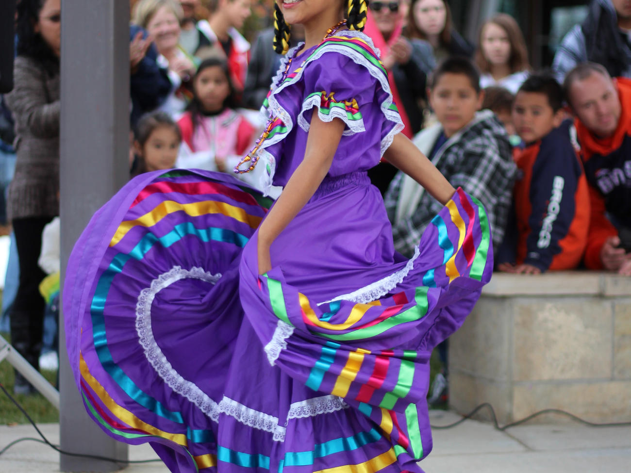 Girl in traditional Mexican purple dress at Day of the Dead event in Longmont, CO