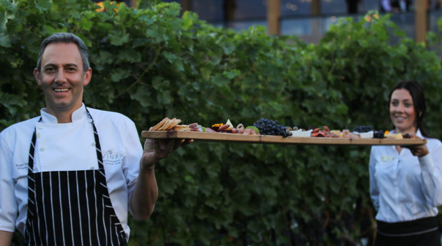 Chef holding platter of meats and cheeses during a winery harvest experience in British Columbia